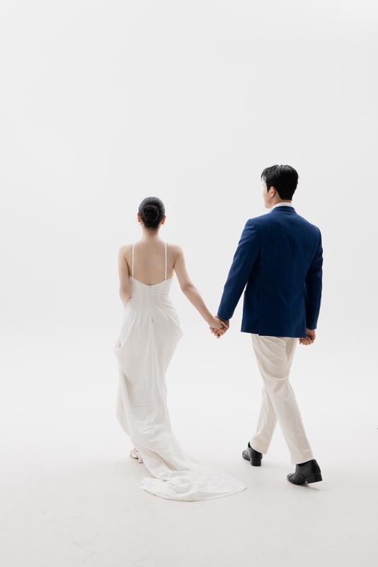 네이비 재킷을 입고 신부와 걸어가는 신랑의 뒷모습